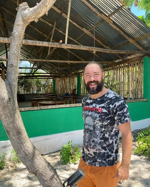 Philip standing in front of Swinging Micky's Irish Pub on Zanzibar, the open-air bamboo and thatch bar behind him